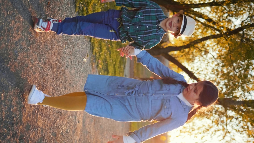 Cute little boy and girl running holding hands. Vertical screen