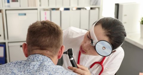 ENT doctor conducts medical examination with otoscope to patient 4k movie
