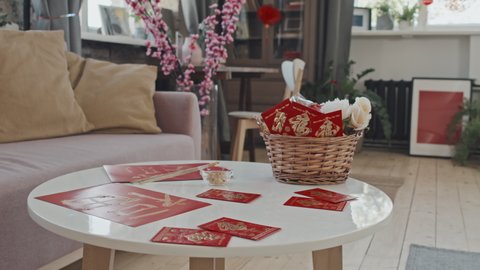 Close up tracking shot of postcards and gift basket on table in living room decorated for Chinese New Year