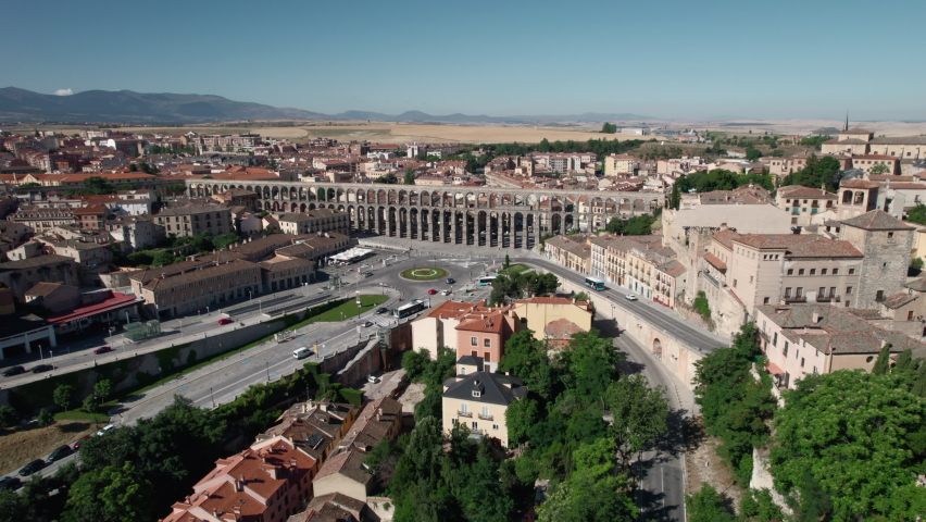 Aerial drone point of view cityscape and medieval ancient Roman Aqueduct, road traffic in busy street near famous landmark of Segovia, Castile and Leon, Spain. UNESCO heritage, travel, tourism concept Royalty-Free Stock Footage #1081792733