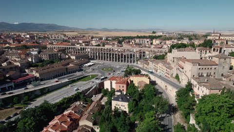 Aerial drone point of view cityscape and medieval ancient Roman Aqueduct, road traffic in busy street near famous landmark of Segovia, Castile and Leon, Spain. UNESCO heritage, travel, tourism concept