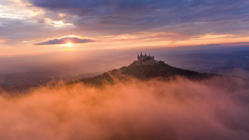 Aerial Forward Scenic View Of Hohenzollern Castle On Mountain, Drone Flying Over Forest