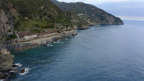 Aerial Ascend Beautiful Shot Of Train Moving On Rock Formation, Drone Flying Over Sea - Cinque Terre, Italy
