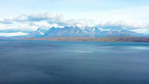 Aerial: Idyllic Shot Of Snowcaped Mountains, Drone Flying Backwards Over Lake - Torres del Paine National Park, Chile