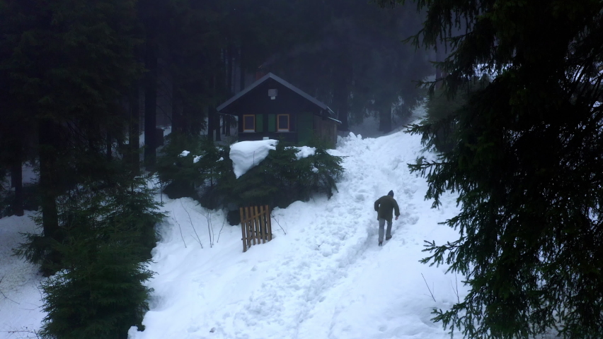 Aerial: Male Tourist Walking Towards House During Winter Season In Forest - Erfurt, Germany