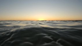 Slow motion clip of waves at sunset.