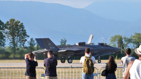 Rivolto, Italy SEPTEMBER, 17, 2021 Panning view spectators at air show watch military aircraft short take-off in sunny day. Lockheed F-35B Lightning II NATO Stealth Fighter Jet of Italian Air Force
