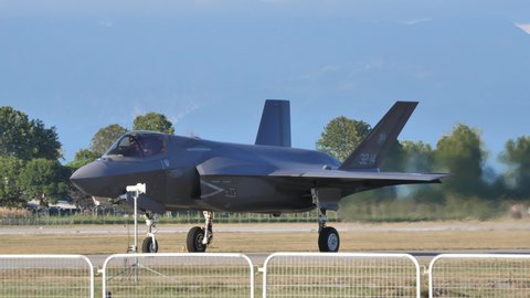 Rivolto Italy SEPTEMBER, 17, 2021 Panning view crowd cheers and wave to pilot on military jet plane landed on runway at air show. Lockheed F-35B Lightning II Stealth Fighter Jet of Italian Air Force