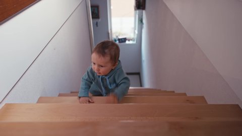 Little boy on wooden stairs at home alone. 