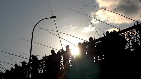 Fishing on the Galata bridge, Istanbul. Fishermen silhouettes. Fishing rods and fishes at autumn at Bosphorus.