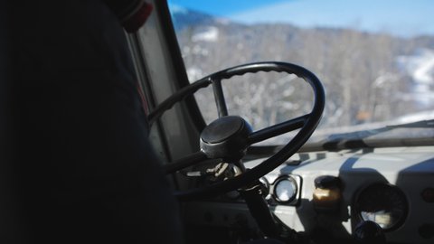 Close-up of the hands of a minibus driver driving a vehicle on a winter road.