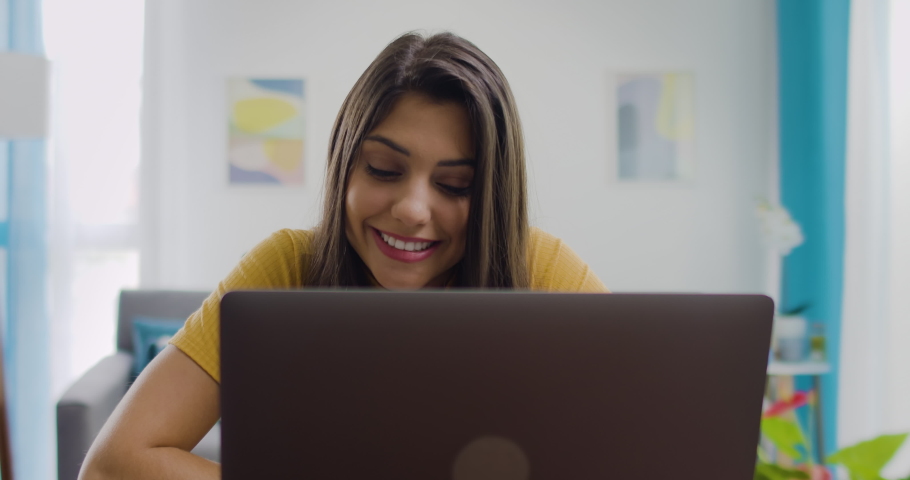 Dolly Out of Confident and Cheerful Caucasian Brunette Woman Typing on Laptop, Young Female Professional Writing an Important Email From Her Home in Modern Living Room. Remote Working. Royalty-Free Stock Footage #1081814702