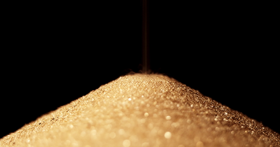 Hourglass. Sands move through hour glass. Sandglass close-up on a black background. Slow motion video. A pile of Golden sand at the bottom of the hourglass, small grains of sand fall from above. Royalty-Free Stock Footage #1081814948