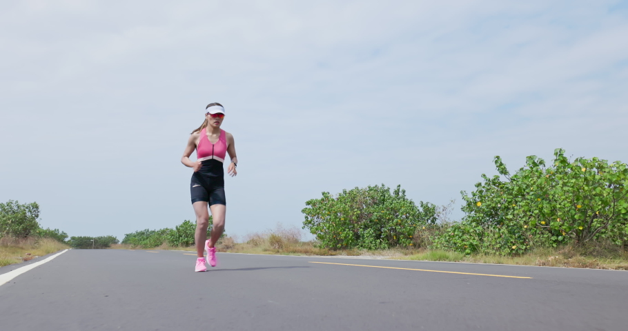 asian woman is running on road training for triathlon or healthy lifestyle and she has knee pain Royalty-Free Stock Footage #1081815959
