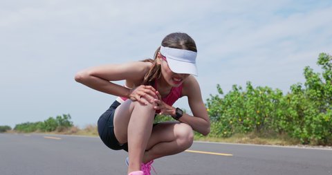 asian woman is running on road training for triathlon or healthy lifestyle and she has knee pain