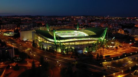 Lisbon , Portugal - 10 31 2021: Aerial view of the traffic in front of the illuminated Jose Alvalade arena, dusk sky in Lisbon - static, drone shot