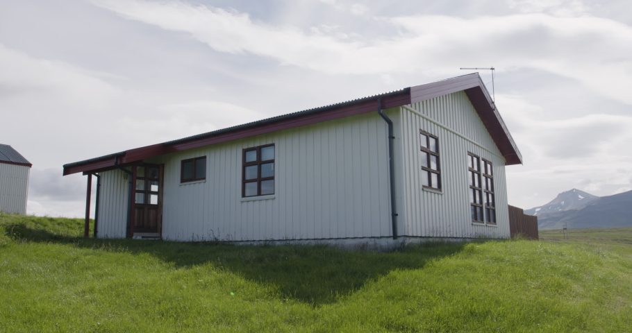 Still shot of a white cabin exterior in the middle of Iceland