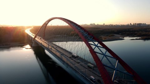 Road bridge against the backdrop of a spectacular sunset. Transport links. Horizontal flyby of a massive structure. Architectural automobile buildings