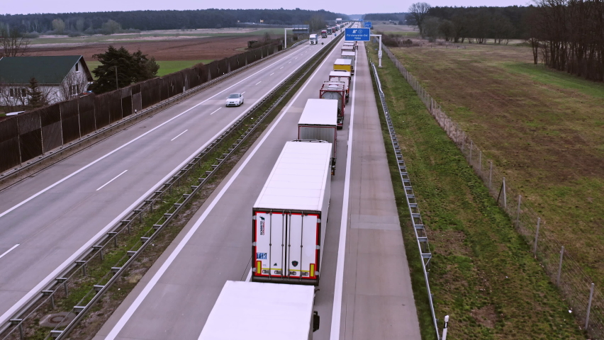 A traffic jam with a long queue of trucks on a German motorway. The trucks are on their way to Poland to get to Ukraine. | Shutterstock HD Video #1081829549