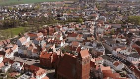 Aerial photos during a sightseeing flight of Perleberg in Brandenburg Germany. You can see the old town with the town hall and the church. The roofs are covered with red tiles. The sun is shining 