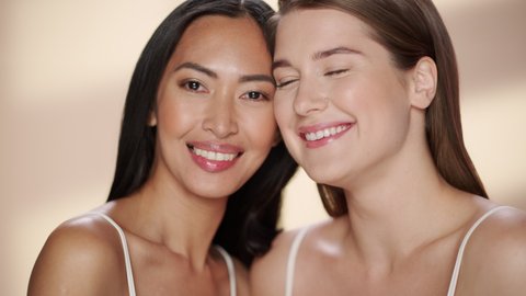 Sensual Beauty Portrait of Two Diverse Multiethnic Models on Isolated Background. Beautiful Happy Asian and Caucasian Women with Natural, Healthy Skin. Wellness, Spa, Cosmetology and Skincare Concept.
