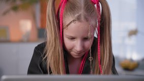 dependent teenager on distance learning playing video games, portrait happy girl with pink pigtails uses laptop