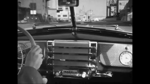 CIRCA 1940s - Excellent footage shot through the windshield of a car as it drives down a waterfront road in an American city.