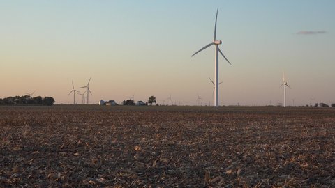 AMERICA - CIRCA 2020s - Huge windmills turn on the flat farmlands of central Indiana and Illinois generating clean energy.