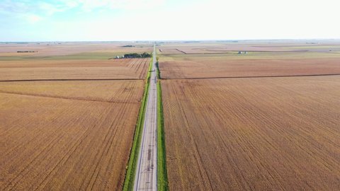 AMERICA - CIRCA 2020s - Excellent aerial of a lone truck traveling on a lonely highway in the farmlands of the midwest, Illinois, Indiana, or Iowa.
