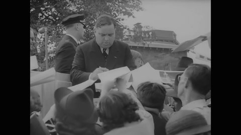 CIRCA 1937 - Mayor La Guardia signs people's programs at the New York Police Academy graduation ceremony.