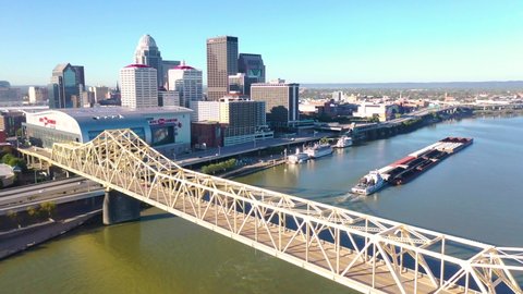 LOUISVILLE, KENTUCKY. - CIRCA 2020s - Aerial of Ohio River barge in front of city skyline of Louisville, Kentucky.
