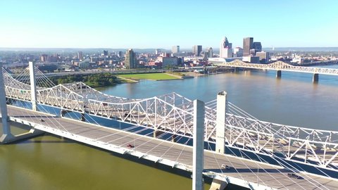LOUISVILLE, KENTUCKY. - CIRCA 2020s - Aerial over Ohio River bridges with the Louisville, Kentucky downtown skyline distant.