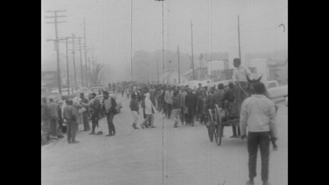 CIRCA 1968 - African-Americans sing as they march and drive horse-drawn wagons for the Poor People's Campaign in Washington DC.