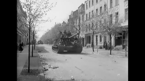 CIRCA 1945 - German Tiger tanks and other military vehicles loaded with German troops roll into Iserlohn, Germany to surrender to American soldiers.
