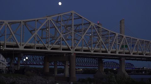 JEFFERSONVILLE, INDIANA - CIRCA 2020s - Night establishing shot of bridges over the Ohio River at Jeffersonville, Indiana and Louisville, Kentucky.