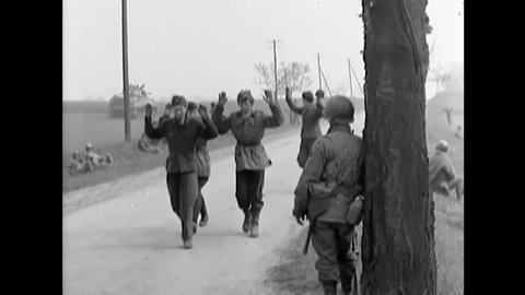 CIRCA 1945 - German POWs surrender to American soldiers, and they carry one of their wounded.