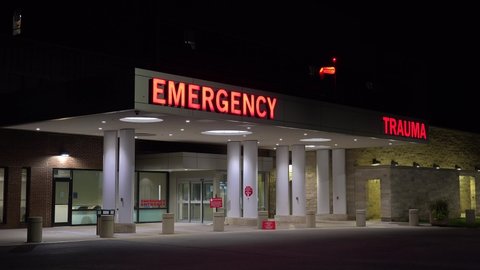 AMERICA - CIRCA 2020s - Good night establishing shot of a generic modern hospital with emergency room and trauma center.