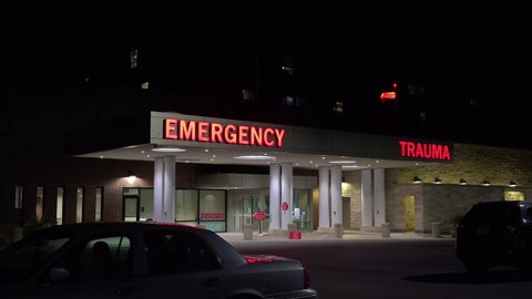 AMERICA - CIRCA 2020s - Good night establishing shot of a generic modern hospital with emergency room and trauma center.