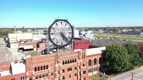 AMERICA - CIRCA 2020s - Aerial of an old clock on the facade of an old abandoned vacant American factory near Jeffersonville, Indiana.