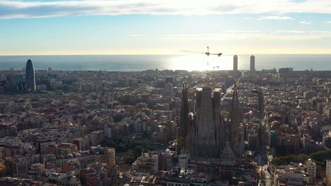 10.04.2019 - Barcelona Spain. Aerial video footage. Sunrise morning view to city center Sagrada Família Basilica of the Holy Family. Eixample blocks Torre Glòries Agbar. the camera rises vertically up