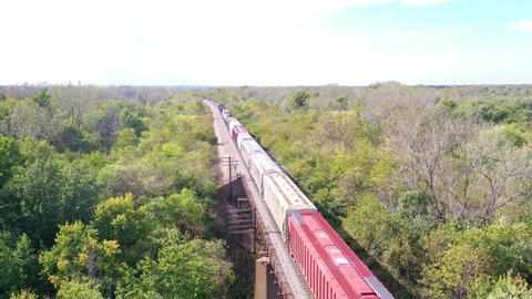AMERICAN MIDWEST - CIRCA 2020s - Aerial of a freight train crossing a steel railway bridge.