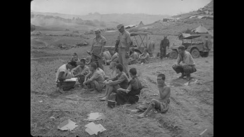 CIRCA 1940s - Interpreters help American soldiers question Japanese POWs on Okinawa.