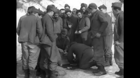 CIRCA 1945 - American soldiers gamble in a crap game in snowy Tazzola, Italy.