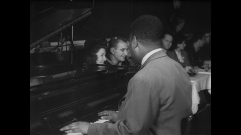 CIRCA 1940s - Nightclub patrons enjoy hearing jazz pianist Art Tatum perform.