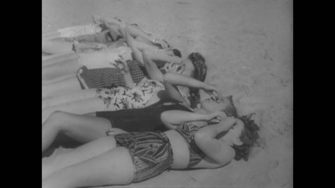 CIRCA 1941 - Bathing beauties sun tan on the beach in Del Monte, California, with humorous fake eyeballs to protect their eyes from the sun.