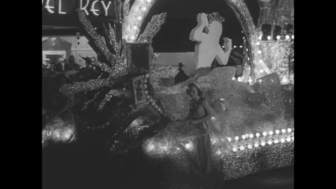 CIRCA 1941 - Brightly lit and distinctive parade floats pass by in a nighttime parade in Memphis, Tennessee.