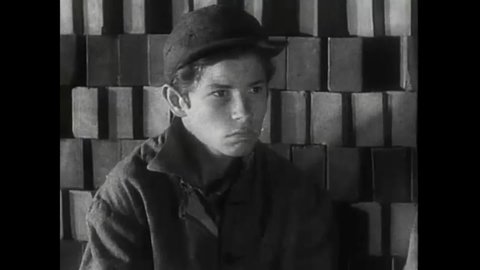 CIRCA 1932 - In this drama film, two bullies prank a kid by giving him bricks to hold and then pantsing him.
