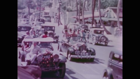 CIRCA 1945 - US Navy sailors and civilians ride vehicles through the streets in Hawaii to celebrate V-J Day.