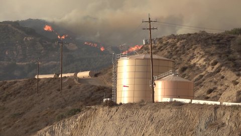 SANTA BARBARA COUNTY, CALIFORNIA - CIRCA 2021 - The Alisal Fire burns near critical infrastructure oil tanks and power lines.