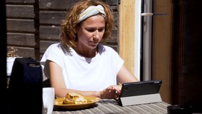 young adult having breakfast and writing with the tablet.Concept of home-working
